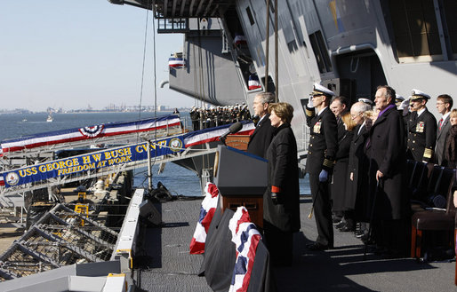 President George W. Bush stands with Mrs. Laura Bush during the playing of the national anthem at the commissioning ceremony of the USS George H. W. Bush (CVN 77) aircraft carrier Saturday, Jan 10, 2009 in Norfolk, Va., in honor of his father, former President George H. W. Bush, seen at right. White House photo by Eric Draper