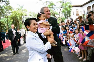 President George W. Bush and Philippine President Gloria Arroyo greet children during a welcoming ceremony at Malacanang Palace in Manila, Philippines, Saturday, Oct. 18, 2003.