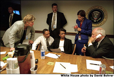 Secure in the Presidential Emergency Operations Center, Vice President Dick Cheney confers with President Bush via telephone and other senior staff, including Karen Hughes (far left), Condoleezza Rice (seated, right) and Mary Matalin (standing, right). White House Photo by David Bohrer.