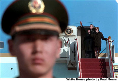 President George W. Bush and Mrs. Bush wave from the top of the steps of Air Force One upon arrival in Beijing, China, Thursday, Feb. 21, 2002. White House photo by Paul Morse.
