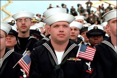 Sailors listen to President George W. Bush aboard the USS Enterprise in Norfolk, Va., on the 60th anniversary of the Pearl Harbor attack Dec. 7, 2001. "Today is an anniversary of a tragedy for the United States Navy," said the President. "Yet, out of that tragedy, America built the strongest Navy in the world. And there is no better symbol of that strength than the USS Enterprise."