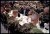 President George W. Bush prays with troops before sharing Thanksgiving dinner at Fort Campbell, Ky., Nov. 21, 2001. "This Thanksgiving, Americans are especially thankful for our freedom," said the President. And we are especially thankful to you, the people who keep us free."