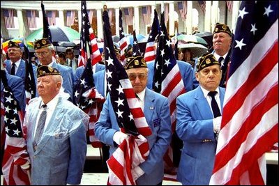 Members of the American Legion hold flags during a Veterans Day ceremony at Arlington National Cemetery in Arlington, Va., Nov. 11, 2002. "This is a place of national mourning and national memory," said the President. "We remember those who served America by fighting and dying on the field of battle. And we remember those veterans who lived on for many decades to serve America in many ways."