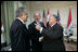 President George W. Bush shakes hands with Iraqi President Jalal Talabani, right, during his visit Tuesday, June 13, 2006, to the U.S. Embassy in Baghdad. With them is U.S. Ambassador to Iraq Zalmay Khalilzad. White House photo by Eric Draper 