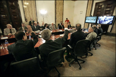 From Baghdad, President George W. Bush and Prime Minister Nouri al-Maliki of Iraq, wave to Vice President Dick Cheney, Secretary of State Condoleezza Rice and Secretary of Defense Donald Rumsfeld in Camp David, Md., during a teleconference Tuesday, June 13, 2006. White House photo by Eric Draper 