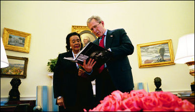 President George W. Bush and Coretta Scott King meet in the Oval Office February 25, 2004 and review a book dedicated to her husband entitled "King: The Photography of Martin Luther King, Jr." by Charles Johnson and Bob Adelman.
