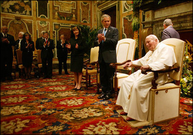 The President and first lady stand and applaud the Pope during their audience with him in June 2004 at which the President presented the Pope with the Medal of Freedom.