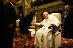 Mrs. Bush takes the hand of Pope John Paul II during the June 2004 visit to Rome by her and President Bush during which they presented the Pope with the Medal of Freedom.