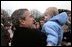 Welcomed by an enthusiastic crowd, President George W. Bush holds a child during an airport arrival greeting at RAF Aldergrove airport in Northern Ireland, Monday, April 7, 2003. 