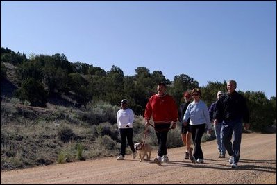 President George W. Bush and Laura Bush walk with Roland Betts, second left, and wife Lois Betts, and other guests Regan and Billy Gammon near the Bett's home outside Santa Fe, N.M., Saturday, May 10, 2003.