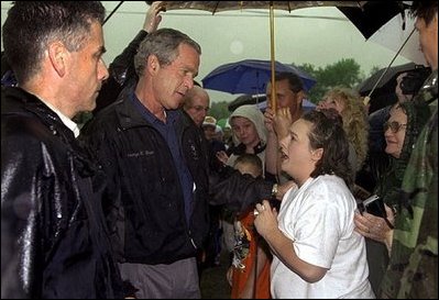 Listening to the story of how a tornado swept through their town, President George W. Bush meets one-on-one with residents during his walking tour of Pierce City, Mo., Tuesday, May 13, 2003. 