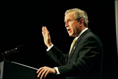 Recalling the experience of watching a Mexican-born Marine take America's oath of citizenship, President George W. Bush raises his right hand as he addresses the National Hispanic Prayer Breakfast in Washington, D.C., Thursday, May 15, 2003. 