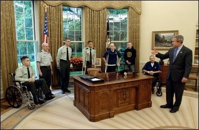 President George W. Bush talks with soldiers after taping his weekly radio address in the Oval Office Friday, May 16, 2003. Honoring Armed Forces Day on May 17th, the President invited soldiers to attend the recording of the address.