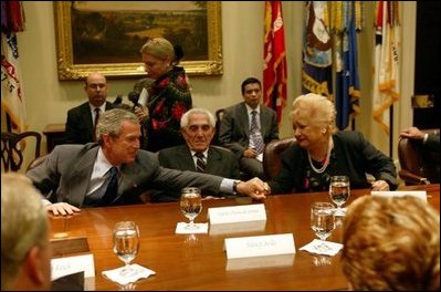 President George W. Bush reaches out to comfort Isabel Roque during a roundtable discussion with Cuban dissidents in the Roosevelt Room at the White House Tuesday, May 20, 2003. Ms. Roque spoke of family members currently imprisoned in Cuba. 