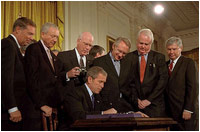 With Senators and members of Congress on hand for the ceremony, President George W. Bush signs the Patriot Act, Anti-Terrorism Legislation, in the East Room Oct. 26, 2001 