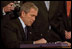With Senators and members of Congress on hand for the ceremony, President George W. Bush signs the Patriot Act, Anti-Terrorism Legislation, in the East Room Oct. 26, 2001 "With my signature, this law will give intelligence and law enforcement officials important new tools to fight a present danger," said the President in his remarks.