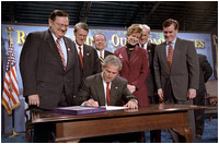 President George W. Bush signs the Small Business Liability Relief and Brownfields Revitalization Act in Conshohocken, Pennsylvania, Jan. 11, 2002. Standing left to right and Rep. Paul Gillmor of Ohio, Rep. Robert Borski of Penn., State Attorney General Mike Fisher, EPA Administrator Christie Todd Whitman, Rep. Joseph Hoeffel of Penn. and Pennsylvania Governor Mark Schweiker. 