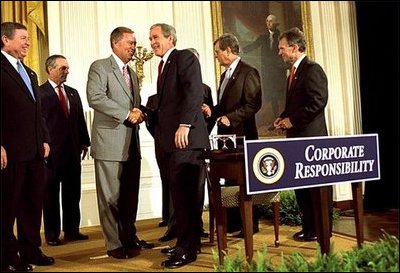 President George W. Bush shakes hands with Congressman Mike Oxley, R-OH, during the signing of the ceremony of the Sarbanes-Oxley Act in the East Room, July 30. "This new law sends very clear messages that all concerned must heed. This law says to every dishonest corporate leader: you will be exposed and punished; the era of low standards and false profits is over; no boardroom in America is above or beyond the law," said the President in his remarks.