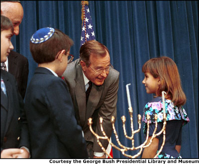 President George H.W. Bush speaks to children at a Menorah Lighting Ceremony. Courtesy the George Bush Presidential Library and Museum.