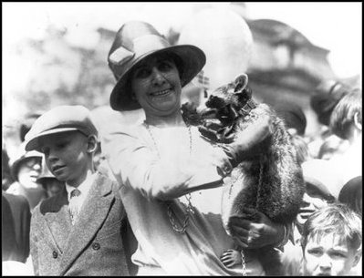 First Lady Grace Coolidge shows off her pet racoon, Rebecca, at the White House Easter Egg Roll April 18, 1927. The president built a little house for Rebecca. 