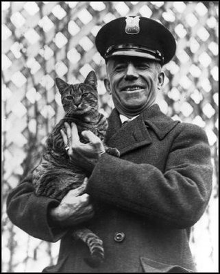 Officer Benjamin Fink holds Tige, the Coolidge's cat, at the White House on March 25, 1924. 
