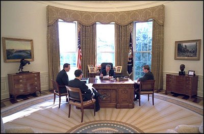 President George W. Bush meets with speechwriters Matt Scully, left, Mike Gerson, center, and John McConnell in the Oval Office Jan. 20, 2003.