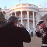 Photo of President Bush saluting a marine as he arrives at the White House.