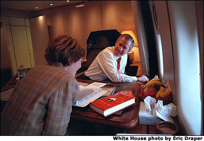 President George W. Bush shares his Air Force One desk with Mrs. Bush as they prepare for the visit to Japan, Saturday, Feb. 16, 2002. White House photo by Eric Draper.