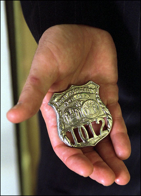 President George W. Bush holds the badge of a police officer killed in the September attacks. "And I will carry this," said President Bush during his address to Congress Sept. 20. "It is the police shield of a man named George Howard, who died at the World Trade Center trying to save others. It was given to me by his mom, Arlene, as a proud memorial to her son. This is my reminder of lives that ended, and a task that does not end." 