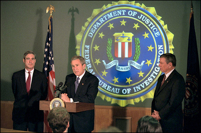 President Bush addresses the media during a tour of FBI headquarters with director Robert Mueller, left, and Attorney General John Ashcroft Sept. 25. The President visited the offices to personally thank employees for their recent and continued efforts since the Sept. 11 attack.