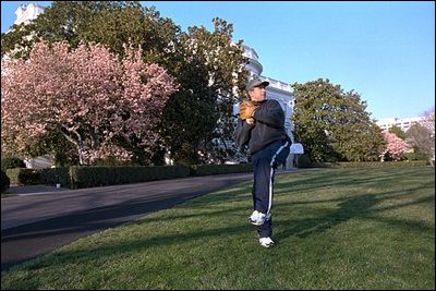 President Bush warms up his pitching arm under the glow of Magnolia trees on the South Lawn April 3, 2001. 