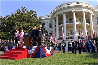 President George W. Bush and Laura Bush stand with Polish President Aleksander Kwasniewski and his wife Jolanta Kwasniewska for the playing of the national anthems for Poland and the United States during the State Arrival Ceremony on the South Lawn of the White House Wednesday, July 17, 2002.