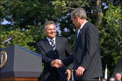 Approaching the podium, President Kwasniewski greets President Bush. "We are grateful to America, you, Mr. President, and your predecessors, for good will and help we have been receiving in Poland for dozen of years -- in all our efforts," said President Kwasniewski, addressing the crowd in English. "Poland is steadfast ally of the United States. We take over the co-responsibility for European and global security. On the 11th of September, all of us felt New Yorkers." 