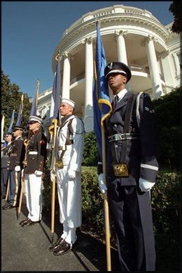 Members from the nation's armed services stand at attention with all the state flags along the drive leading up to the White House.
