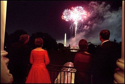 As explosions of color light up the night sky and the glowing faces of guests, the two first couples watch fireworks from the Truman Balcony. 