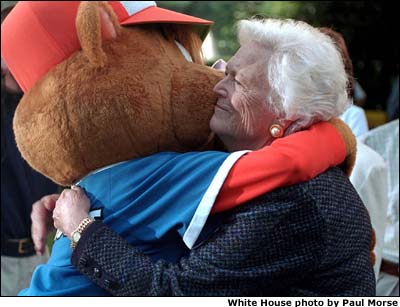 Barbara Bush, the President's mother, hugs the Little League mascot at game's end.White House photo by Paul Morse