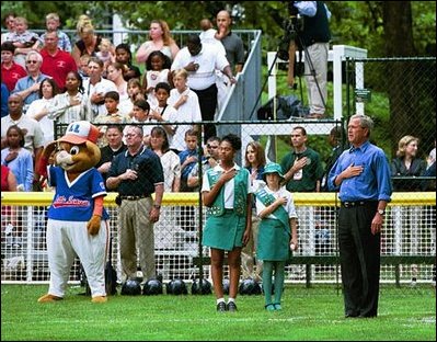 President Bush starts off the first game of the 2004 White House Tee Ball season with the pledge of allegiance June 13, 2004. Standing with the President are members of Girl Scout Troop 