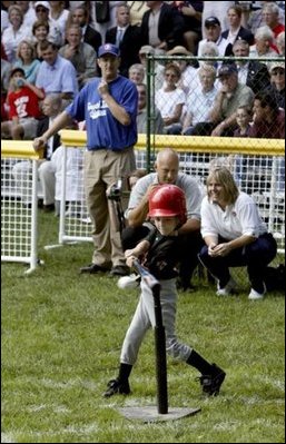 A little slugger from Kalamazoo, Mich., takes his hit under the expert gaze of Honorary Commissioner and Baltimore Orioles great Cal Ripken and Olympic Gold Medalist and Honorary Third Base Coach Dot Richardson during the last game of the White House South Lawn Tee Ball season Sunday, Sept. 7, 2003.