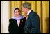 President George W. Bush greets Dr. Raja Habib Khuzai of the Iraqi Governing Council after delivering remarks on Women's Human Rights in the East Room of the White House Friday, March 12, 2004.