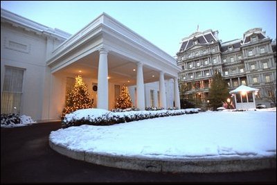 The West Wing entrance glows as the sun rises on a snowy day at the White House, Friday, Dec. 6, 2002. 