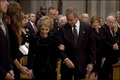 President George W. Bush escorts former First Lady Nancy Reagan to her seat before the funeral service for former President Ronald Reagan at the National Cathedral in Washington, DC on June 11, 2004. 