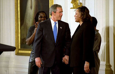 President George W. Bush congratulates Pamela Hedrick during a ceremony honoring graduates of welfare-to-work programs in the East Room Jan. 14, 2003.