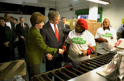 President George W. Bush and Laura Bush greet volunteers at the Capital Area Food Bank in Washington, D.C., Jan. 19, 2002.