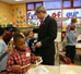 President George W. Bush talks with Kasey Stevenson and other students as he signs autographs during a visit to an after-school classroom program at the Providence Family Support Center in Pittsburgh Monday, March 7, 2005. White House photo by Susan Sterner