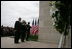 President George W. Bush and Laura Bush, accompanied by Sgt. Timothy Boyd of the Military District of Washington, stand before a memorial wreath Monday, Sept. 11, 2006, during a moment of silence at the Pentagon in Arlington, Va., to commemorate the fifth anniversary of Sept. 11, 2001 attacks.