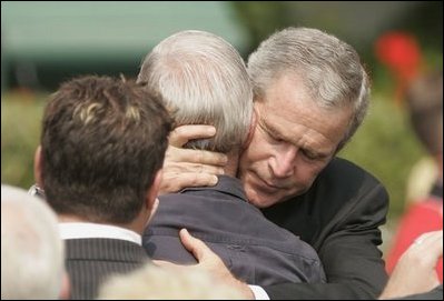 President George W. Bush embraces one of the hundreds of family and friends who gathered on the South Lawn of the White House, Friday, Sept. 9, 2005, during the 9/11 Heroes Medal of Valor Award Ceremony, in honor of the courage and commitment of emergency services personnel who died on Sept. 11, 2001. 