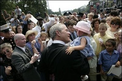 President George W. Bush holds Keira Corrigan of Mineola, N.Y., as he meets some of the hundreds of family and friends who gathered on the South Lawn of the White House, Friday, Sept. 9, 2005, during the 9/11 Heroes Medal of Valor Award Ceremony, in honor of the courage and commitment of emergency services personnel who died on Sept. 11, 2001.