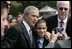 President George W. Bush poses for a photo with a young man wearing a button in honor of 9/11 victim, Yamel J. Merino, as he met some of the hundreds of families and friends who gathered on the South Lawn of the White House, Friday, Sept. 9, 2005, during the 9/11 Heroes Medal of Valor Award Ceremony, in honor of the courage and commitment of emergency services personnel who died on Sept. 11, 2001.