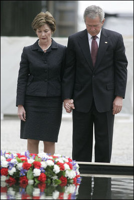 President George W. Bush and Laura Bush stand in silence after laying a wreath in the north reflecting pool at Ground Zero September 10, 2006, in commemoration of the fifth anniversary of the terrorist attacks of September 11, 2001, on the World Trade Center in New York City.