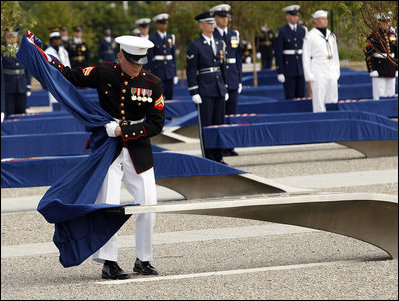 A Marine removes a ceremonial cloth during the unveiling of 184 memorial benches at the 9/11 Pentagon Memorial Thursday, Sept. 11, 2008, during the dedication of the 9/11 Pentagon Memorial at the Pentagon in Arlington, Va.